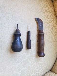 three old tools are sitting on the back of a couch