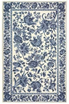 a blue and white rug with flowers on the bottom, in front of a white background