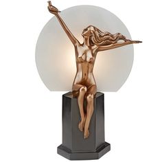 a bronze statue with a white light on it's head and hands in the air