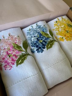 four white napkins with colorful flowers on them