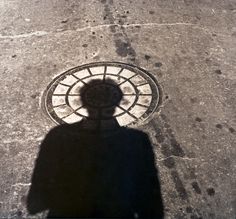 the shadow of a person standing in front of a fire hydrant