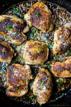 chicken thighs in a skillet with parmesan cheese and chives on top