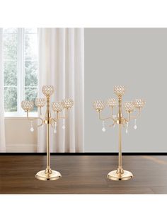 two gold candelabra stands with crystal drops