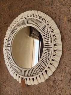 a round mirror hanging on the side of a wall