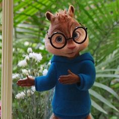 a toy squirrel with glasses and a blue sweater is standing in front of a mirror