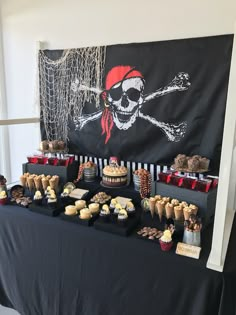 a pirate themed dessert table with cupcakes and cakes