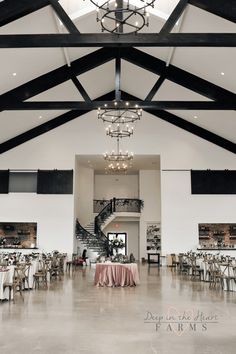 the inside of a building with tables and chairs set up for a formal dinner or function