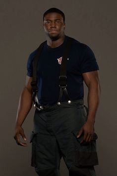 a man in black shirt and suspenders standing with his hands on his hipss