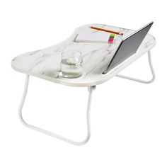 a laptop computer sitting on top of a white table with a cup and pencils