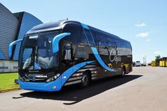 a blue and black bus parked in front of a building