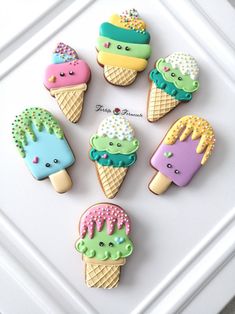 decorated ice cream cookies with sprinkles and frosting on white tray next to wall