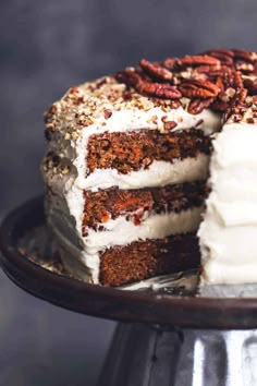 a cake with white frosting and pecans on top