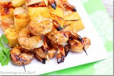 grilled shrimp and pineapple skewers are served on a white square plate