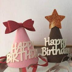 two birthday hats with bows on them sitting next to each other