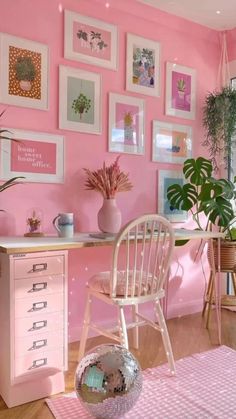 a room with pink walls and lots of pictures on the wall, including a chair