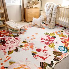 a baby crib with a flowered rug on the floor next to a toy horse