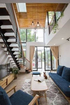 a living room filled with blue couches and a coffee table next to a stair case