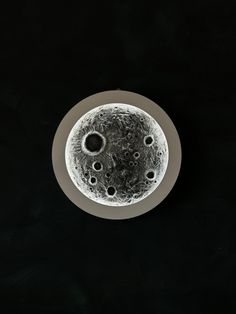 an overhead view of the surface of a plate with water droplets on it and black background