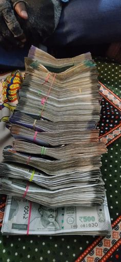 a pile of papers sitting on top of a table next to a person's leg