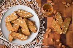 almonds and cookies on a plate next to a glass of beer