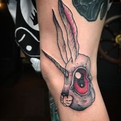 a woman's leg with a tattoo on it that has a skull in the shape of a head