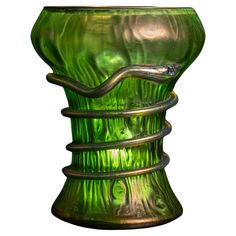 a green glass vase sitting on top of a table