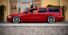 a red station wagon parked in front of a building