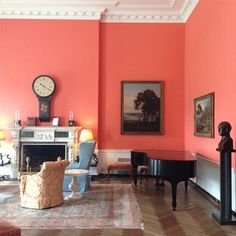 a living room filled with furniture and a clock mounted to the side of a wall