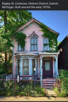 an old pink house with ivy growing on it's roof and front porch in michigan, built around the early 1970's