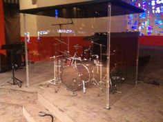 a drum set is sitting on the floor in front of a stained glass display case