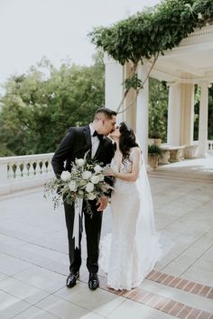 a bride and groom standing in front of a gazebo