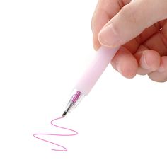 a hand holding a pink pen with writing on it