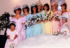 a group of women in dresses and hats posing for a photo with their bridesmaids