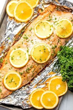 baked salmon with lemons and parsley on aluminum foil, ready to be served