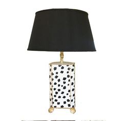 a black and white lamp on a table next to a wall with an image of a dog