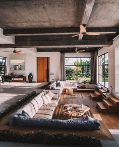 a living room filled with lots of furniture next to a large open floor plan window