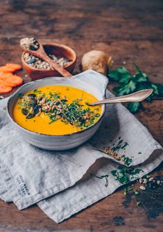 a bowl of carrot soup on top of a napkin