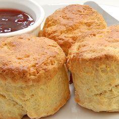 two biscuits on a plate with ketchup and dipping sauce