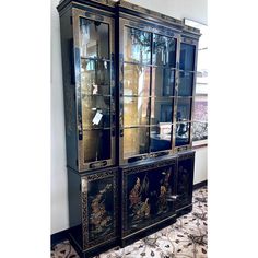 an ornate china cabinet with glass doors and gold trimmings on the front, in a living room