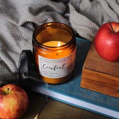 an apple sits next to a candle on a tray