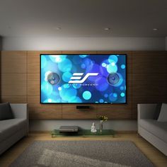 a living room with couches and a flat screen tv mounted on the wall above it