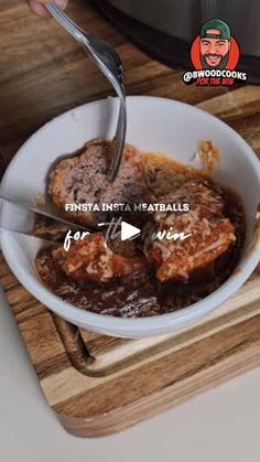 a bowl filled with meat and gravy on top of a wooden cutting board