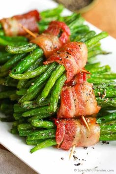 a plate topped with asparagus covered in bacon