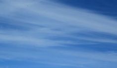 a person is flying a kite in the air on a sunny day with blue skies and white clouds