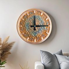 a large clock mounted to the side of a wall next to a couch and table