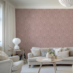 a living room with pink wallpaper and white furniture