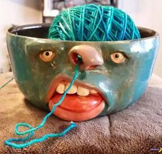 a bowl with yarn in the shape of a face