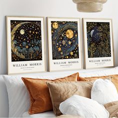 three posters on the wall above a bed in a room with white walls and pillows