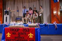 a group of people standing in front of a table with candles and signs on it