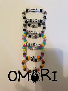 Bracelets I made based off of Omori characters! They are colorful, well made, and stretchy so they fit everyone!  Every bracelet has 27-28 beads including the letters. Sbg Webtoon Bracelet, Couple Kandi Bracelets, Keroppi Bracelet, Omori Kandi, Scene Kandi Bracelets, Character Kandi, Matching Kandi Bracelets, Bracelet Ideas Beads, Pokemon Bracelet